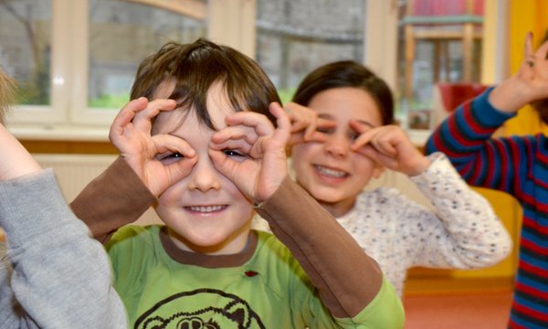 Kinder, die sich ihre Hände vor ihre Augen halten