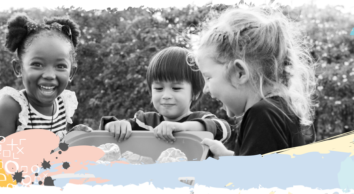 Schwarz-weiß Foto mit drei Kindern, die zusammen eun Behältnis festhalten.